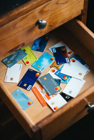 Open desk drawer filled with multiple prepaid Visa and Mastercard gift cards for discreet purchases